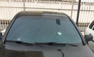 Viatura descaracterizada da Polícia Civil com marca de tiros