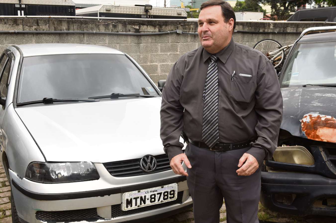 O delegado José Lopes, ao lado do carro usado pelo sequestrador da Thayná; veículo foi apreendido em uma oficina de Guarapari