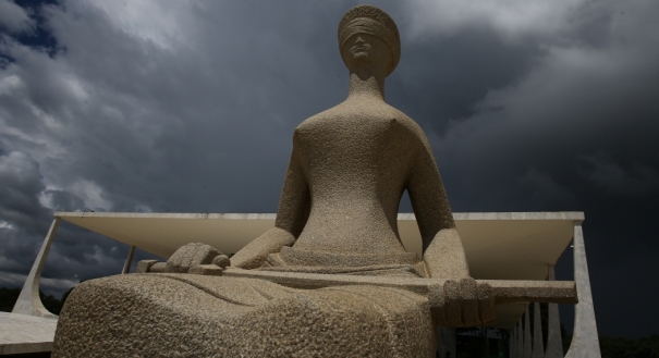 Nuvens carregadas vistas sobre a estátua da Justiça, em frente ao prédio do Supremo Tribunal Federal (STF), em Brasília, na manhã desta quarta-feira