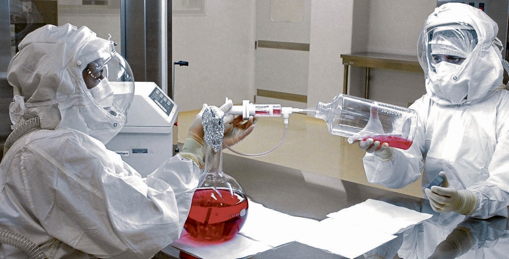 Profissionais manipulam material para produção de vacina: proteção e cuidado para evitar contaminações. Crédito: Ilicciev/Bio-Manguinhos/Fiocruz