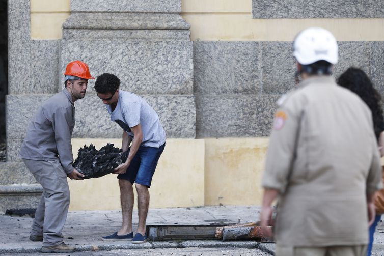 Pesquisadores e funcionários retiram peças dos escombros do Museu Nacional após incêndio. Crédito: Tomaz Silva/Agência Brasil