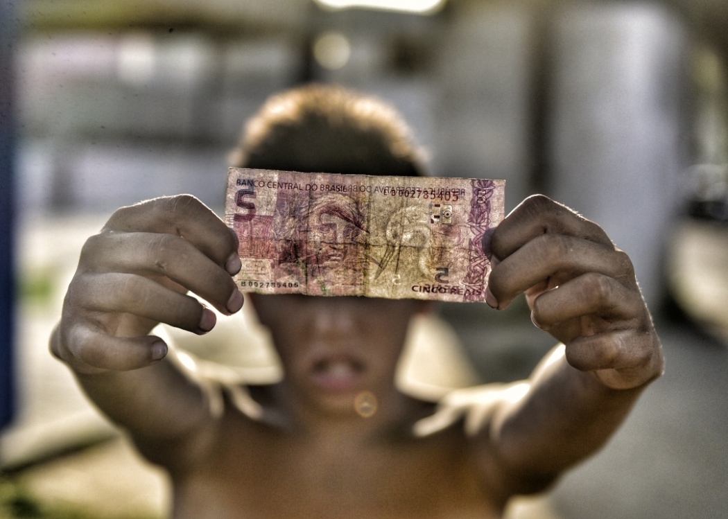 Acostumado a receber poucas moedas, garoto exibe nota de R$ 5 que ganhou de um motorista