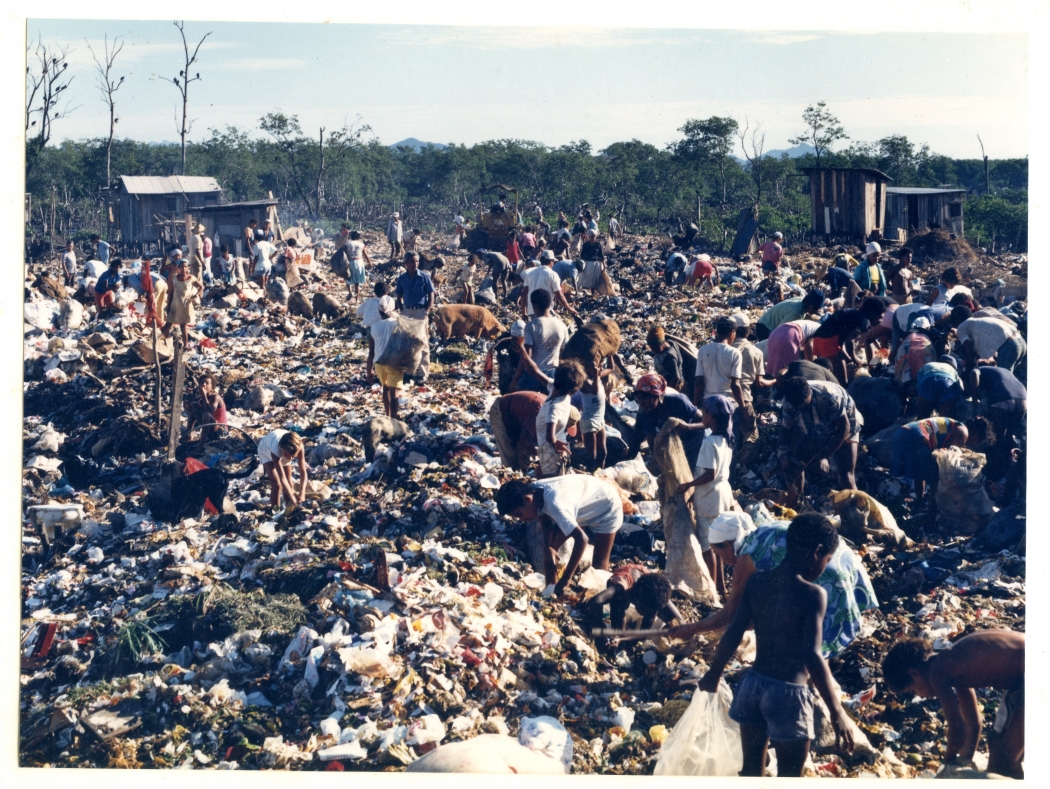 Lixão de São Pedro. Catadores coletando resíduos. Ao fundo, Casebres e  manguezal